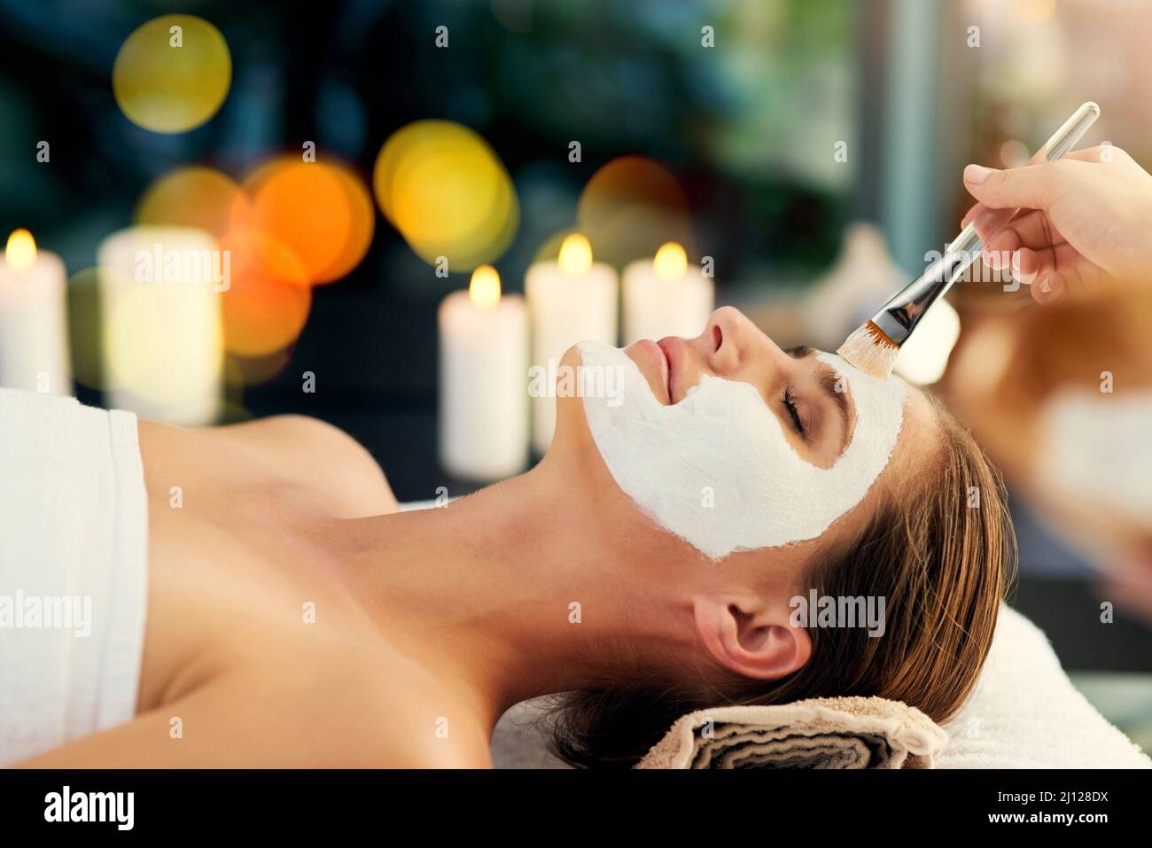 You can never have too many facials. Shot of a beautiful young woman lying on a massage table at the day spa. Stock Photo