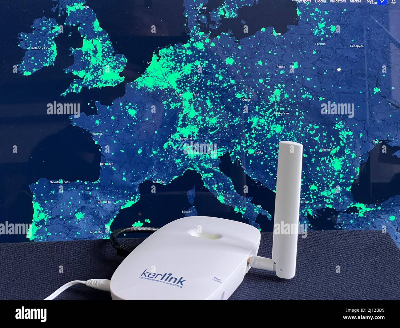 Berlin, Germany. 17th Mar, 2022. A radio hotspot of the Helium network in  front of a map of network coverage (Europe). Helium can be used to connect  devices such as e-scooters, smart