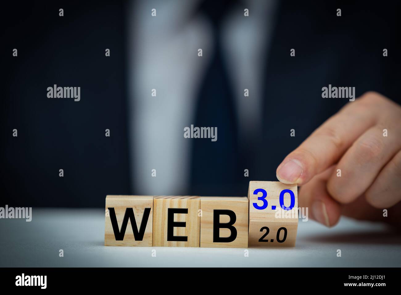 Businessman turns a wooden cube and changes words WEB 2.0 to WEB 3.0. Business, technology and WEB 3.0 concept. Stock Photo