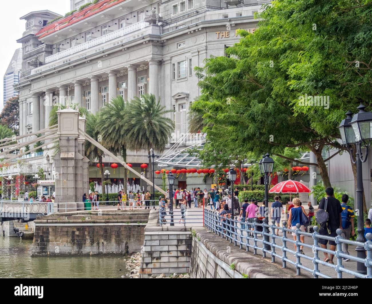 The Cavenagh Bridge and the Fullerton Hotel at the end of the Boat Quay walkway - Singapore Stock Photo