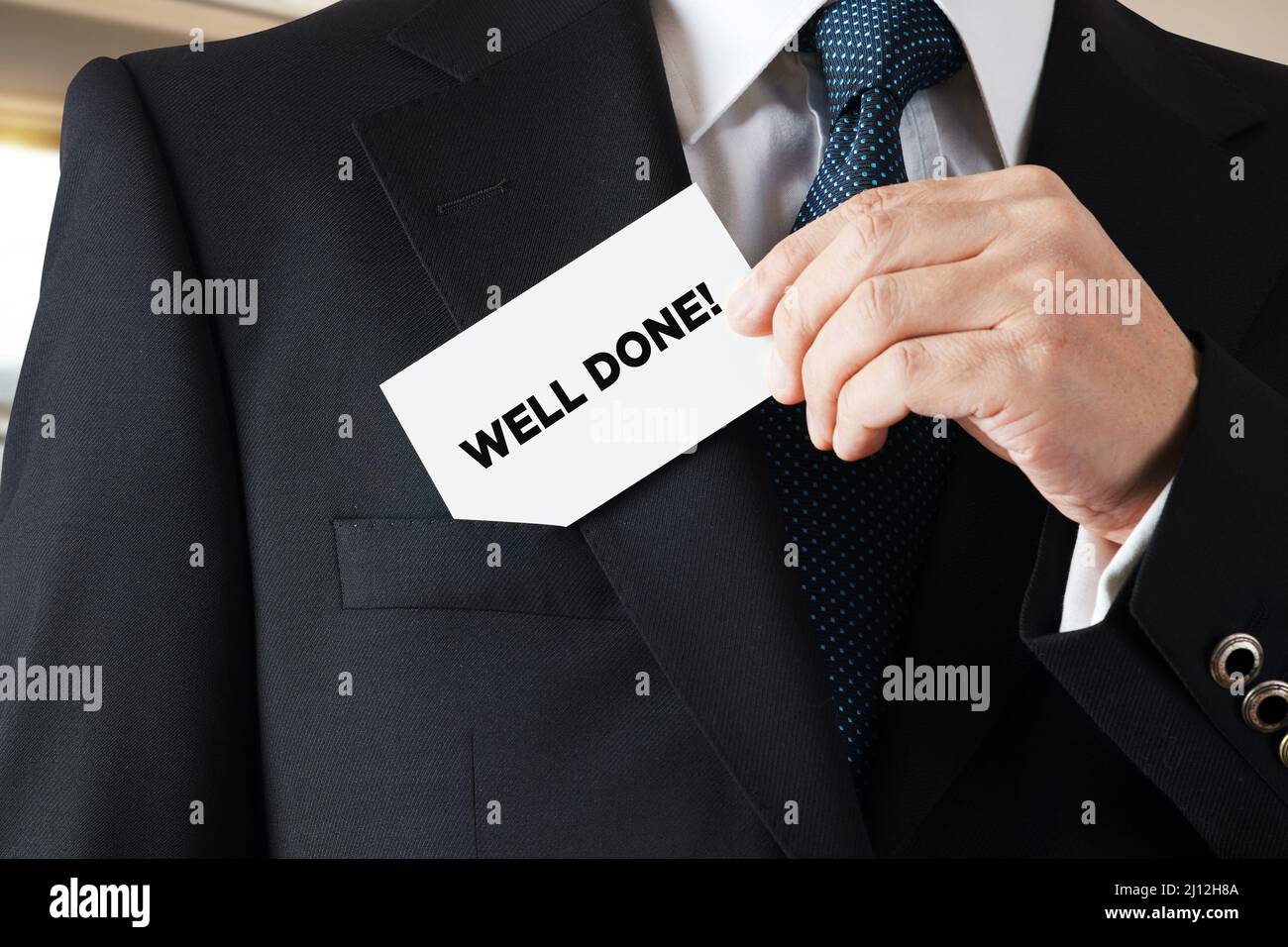 Businessman takes out a business card from his pocket with the message well done. Stock Photo