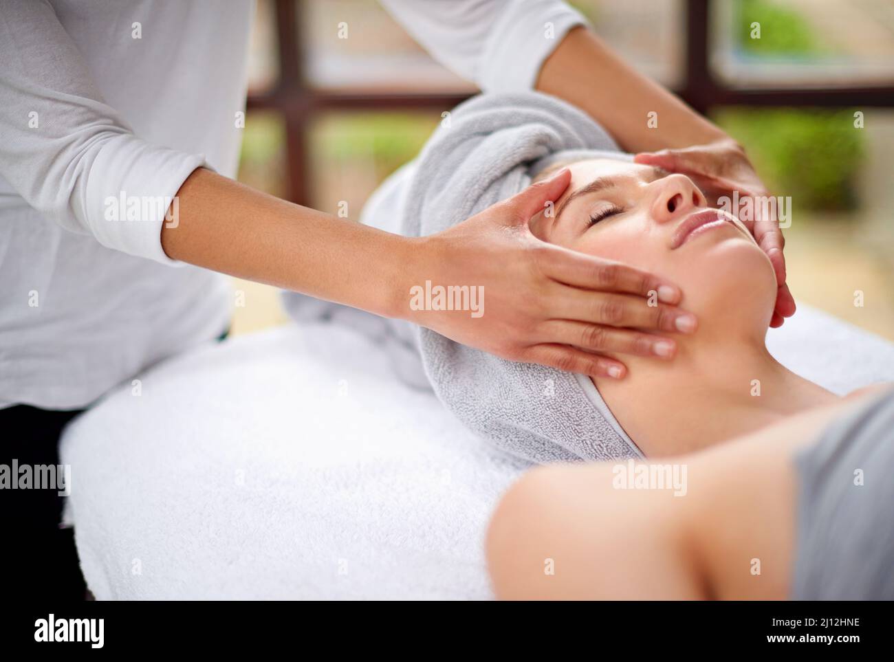 Getting rid of all the tension. Cropped shot of a young woman enjyoing a massage at the day spa. Stock Photo
