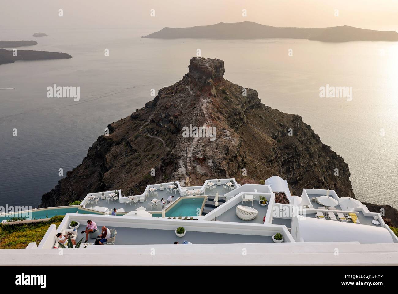 Imerovigli, Santorini, Greece - July 1, 2021: Tables on the restaurant terrace with a picturesque view of the sunset in Imerovigli. Santorini, Greece. Stock Photo