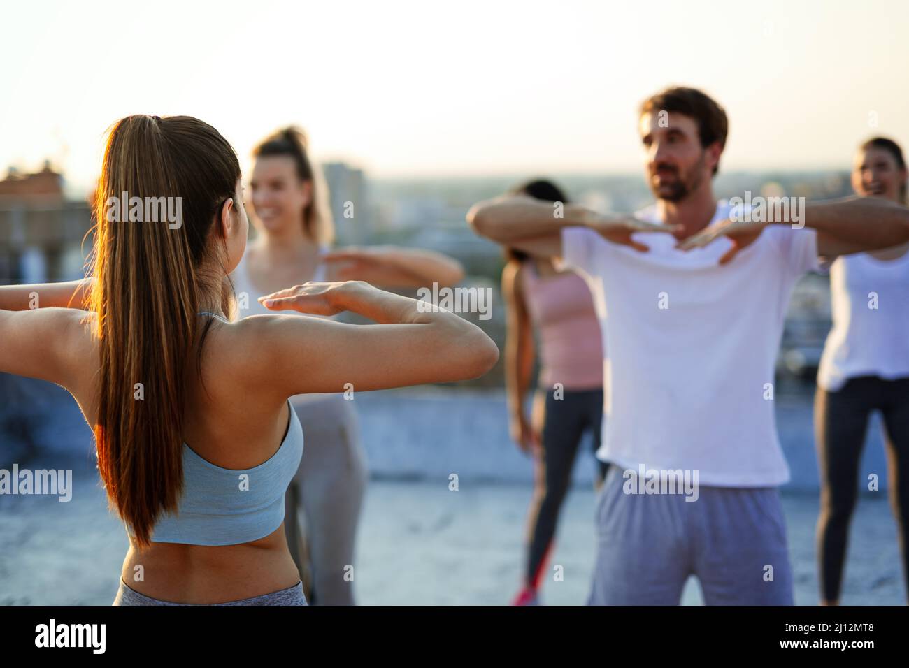 Group of happy fit friends exercising together outdoors. Sport people healthy lifestyle concept Stock Photo