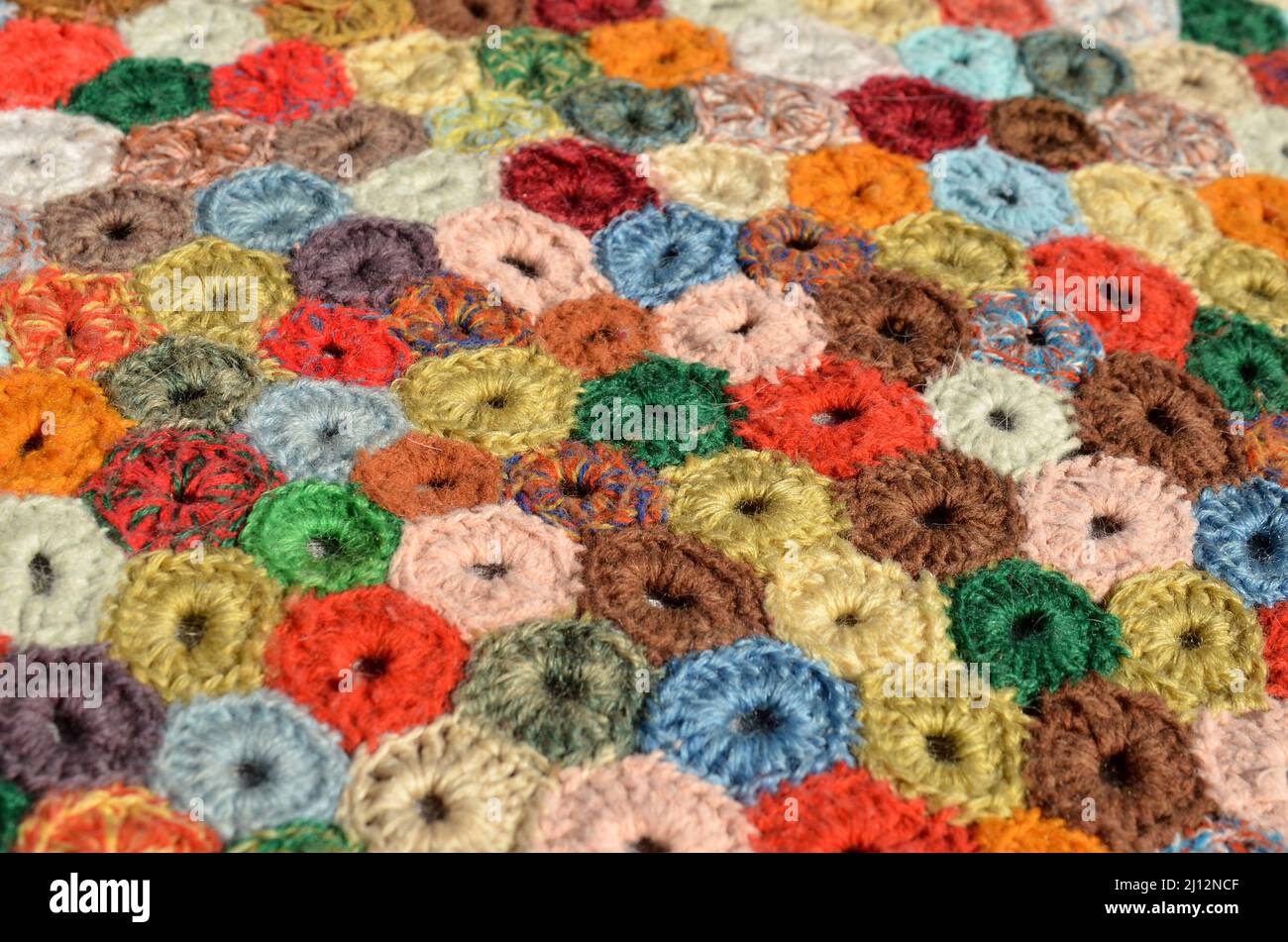 Closeup on a crocheted patchwork rug. Stock Photo