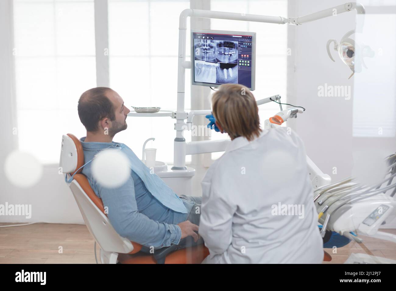 Senior orthodontist woman with face mask explaining dentistry