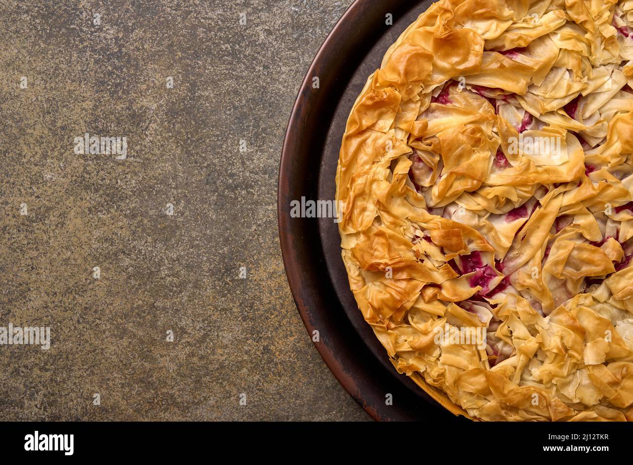 Homemade cherry pie from filo dough on wooden background. Top view. Copy space. Close up Stock Photo