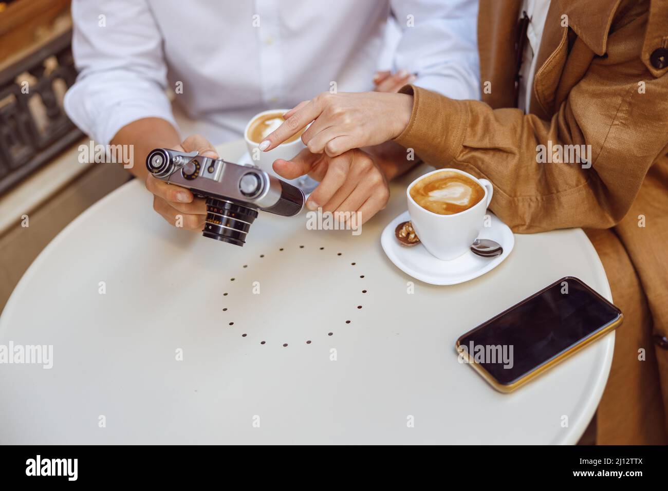 Close-up of male hands holding photocamera over table Stock Photo