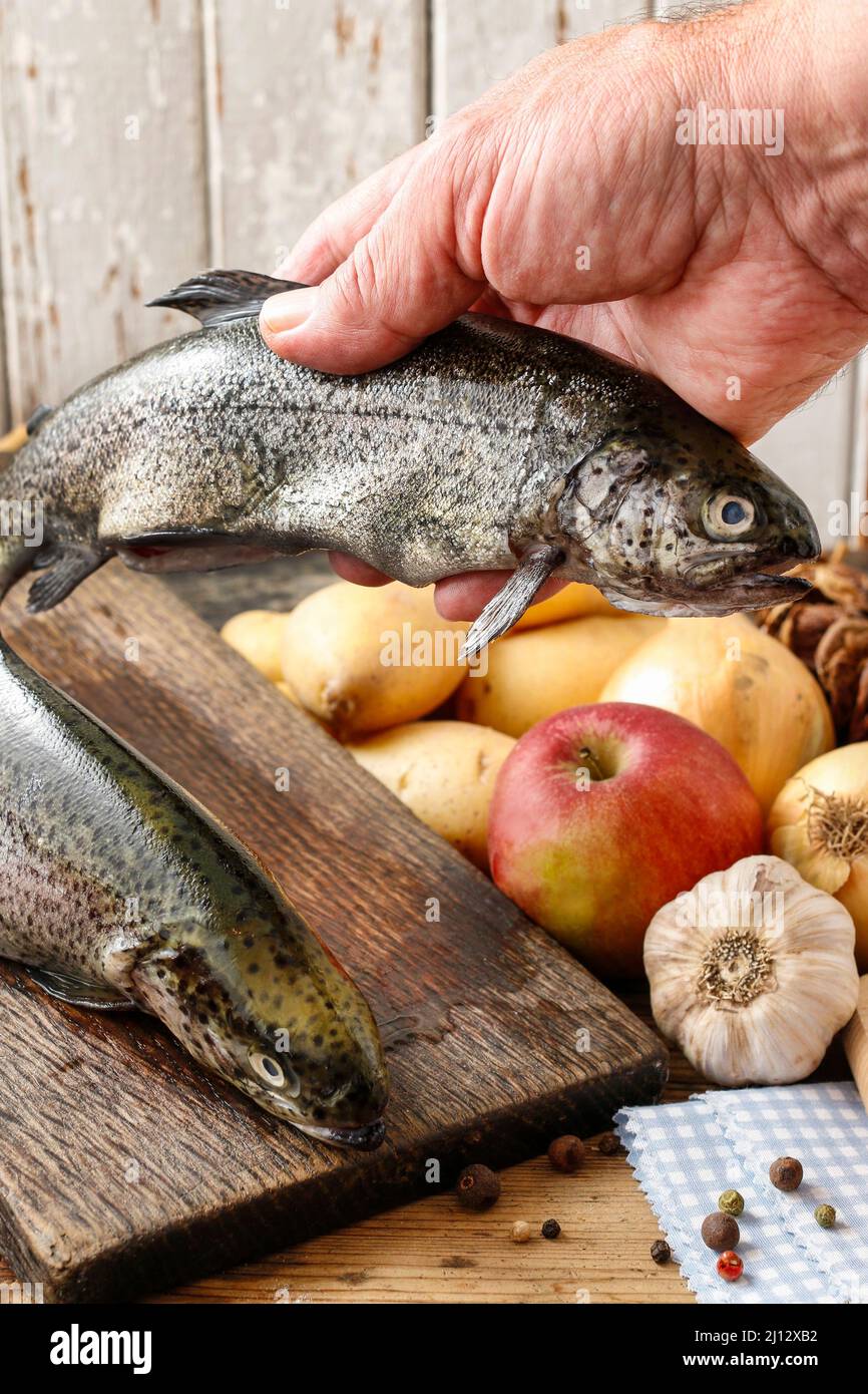 Cook holding a rainbow trout. Cooking time Stock Photo Alamy