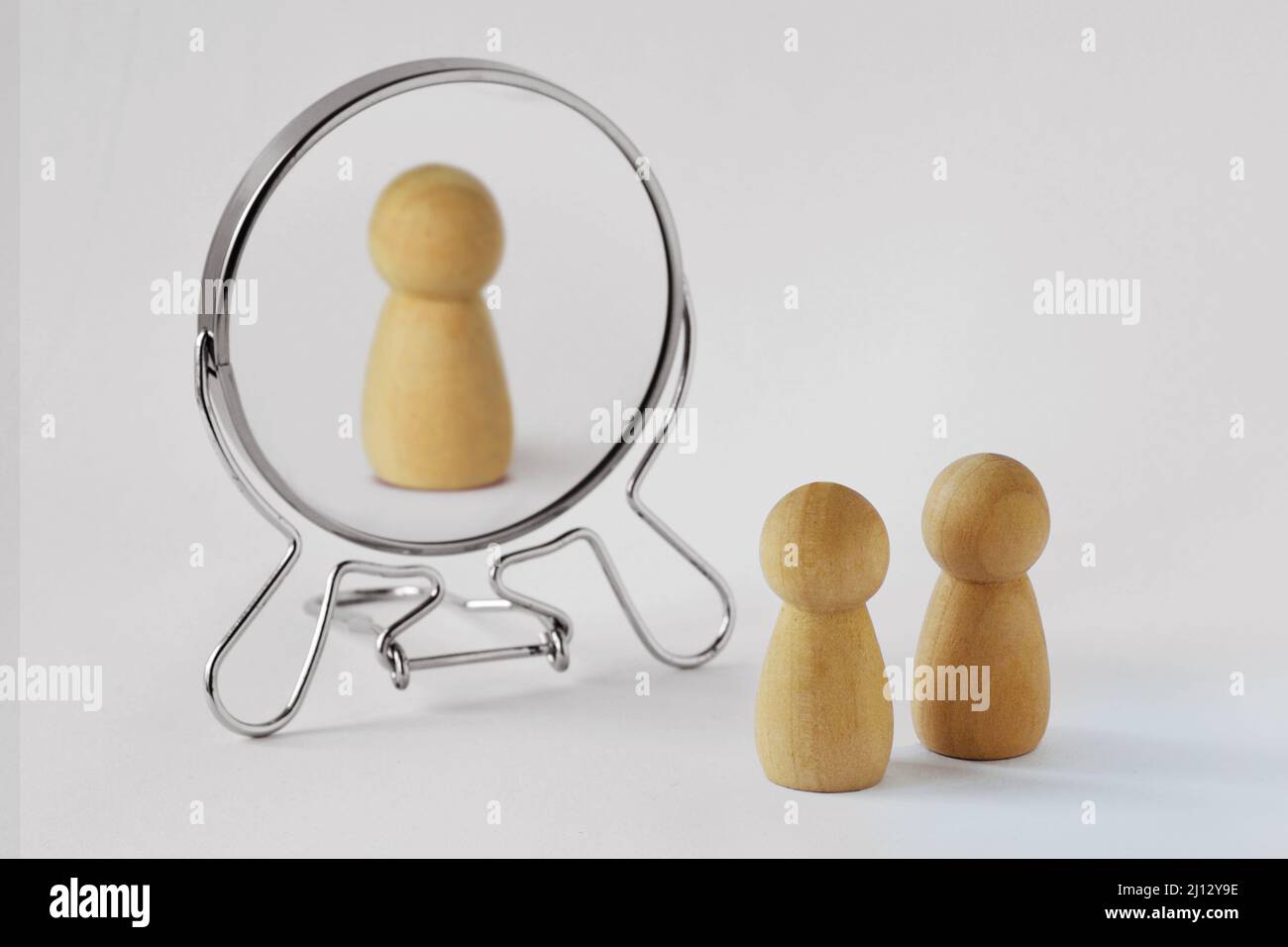 Couple of pawns looking in the mirror with just one of them reflected in it - Concept of egoism and narcissist Stock Photo