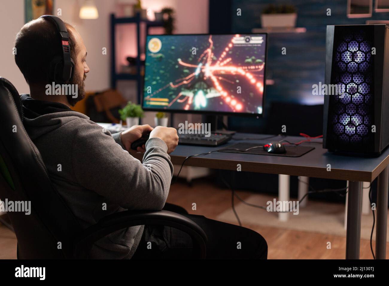 Gamer using controller to play online video games on computer. Man playing  game with joystick and headphones in front of monitor. Player having gaming  equipment, doing fun activity Stock Photo - Alamy