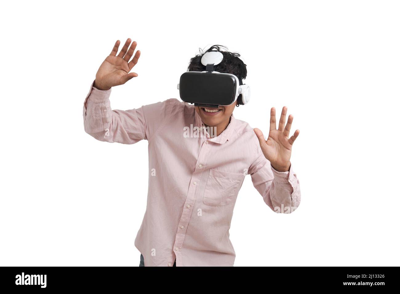 Young peruvian man laughing using virtual reality headset, isolated. Stock Photo
