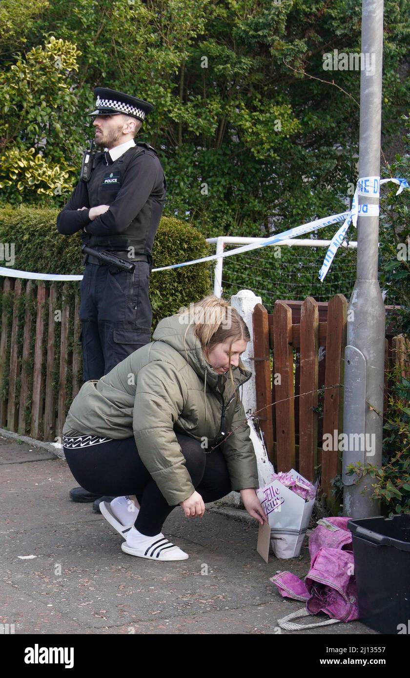 A woman lays flowers at a house in St Helens after a 17monthold girl