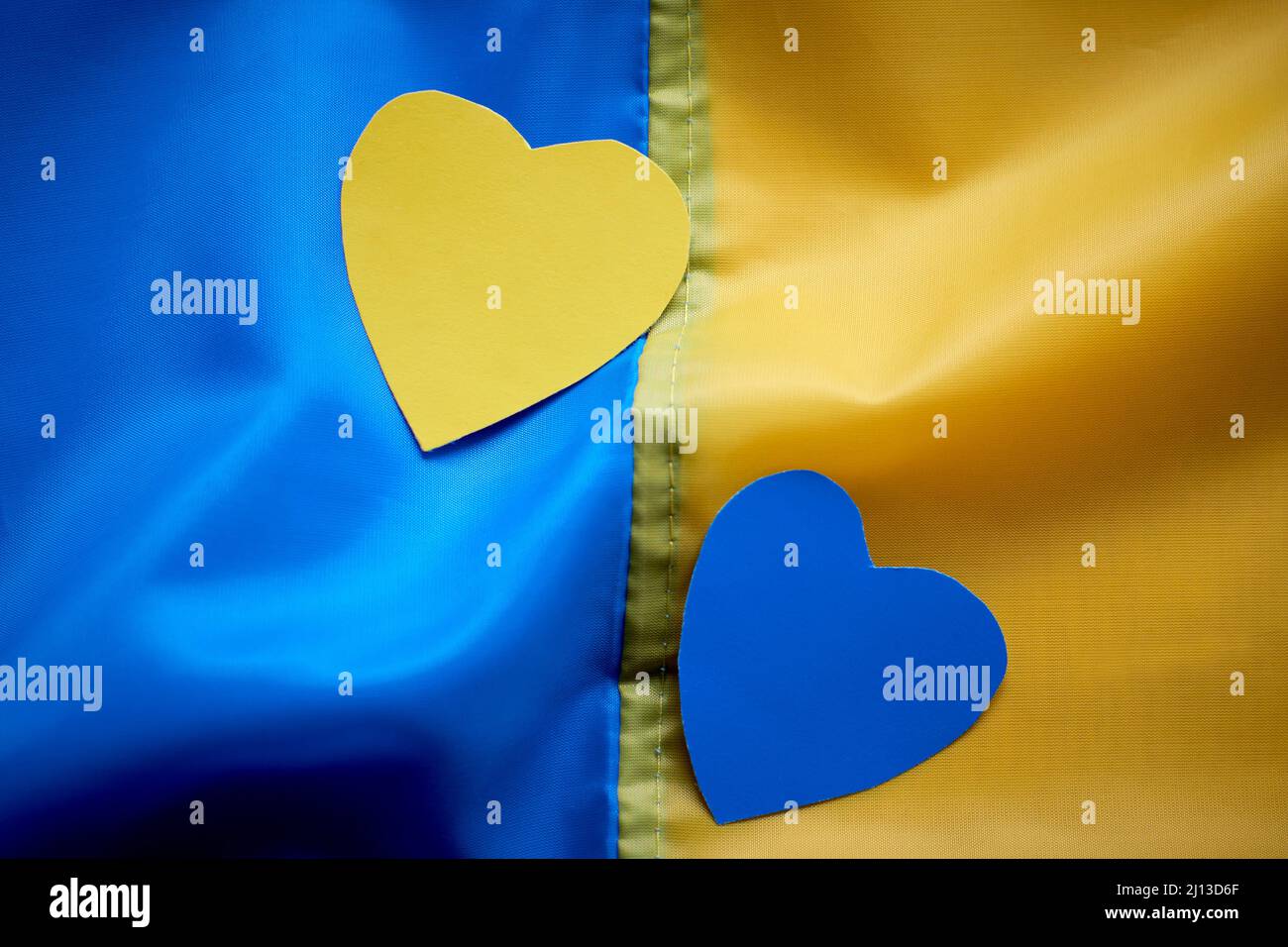 Child hands holding yellowblue paper hearts on Ukrainian