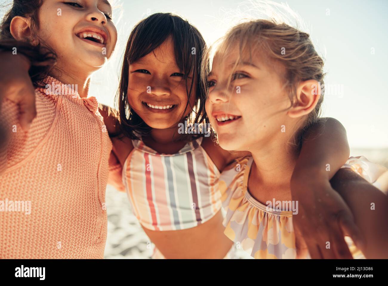 Capturing happy summer moments. Three happy little girls smiling for a