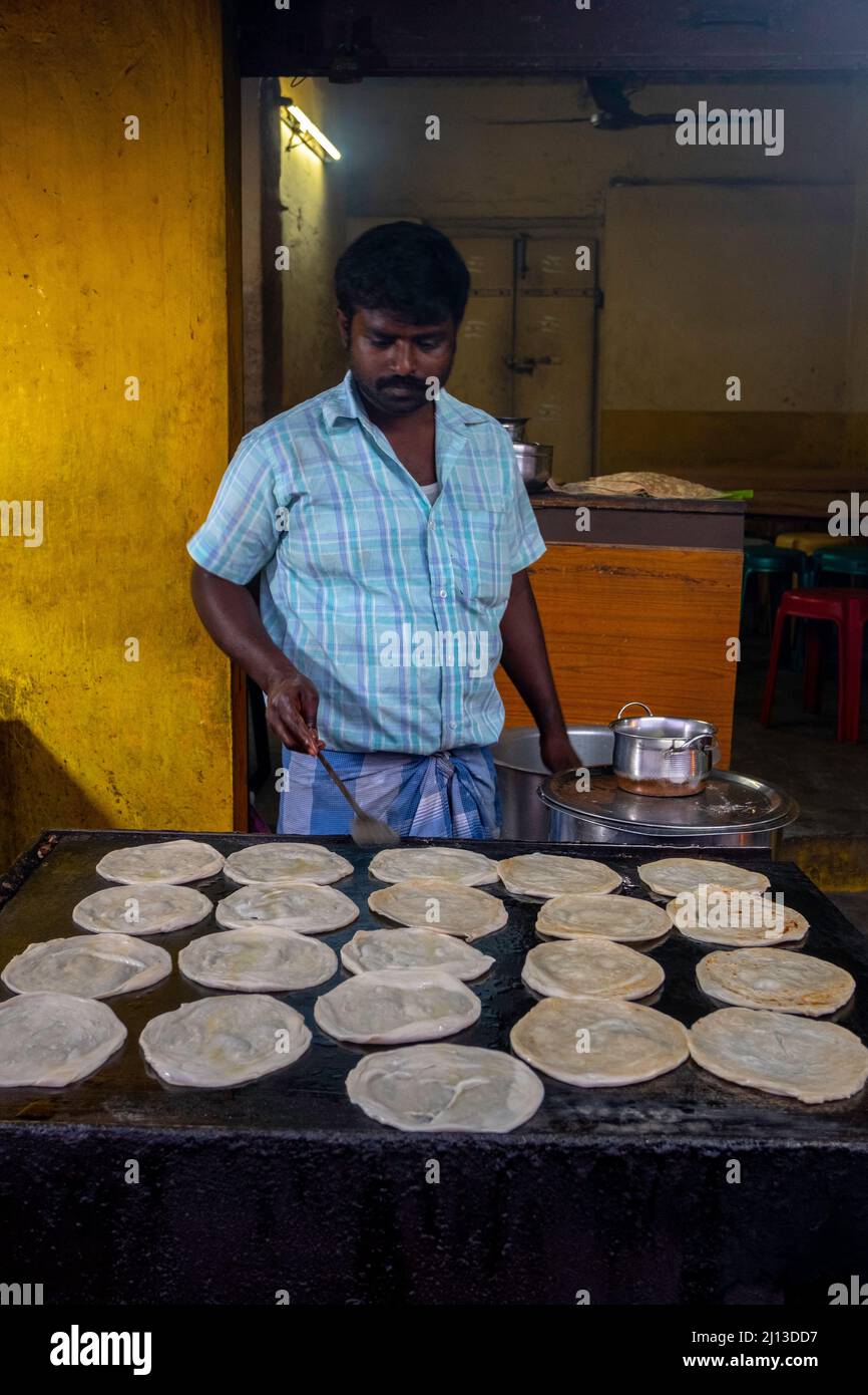 Street vendor preparing and selling Parotta Bread at the food market in