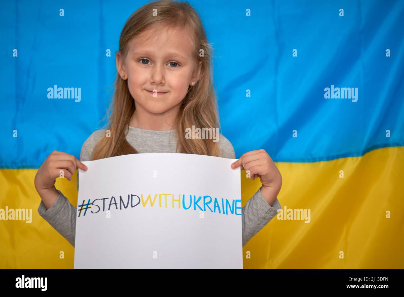 Girl hands holding paper banner with drawn yellowblue staywithUkraine