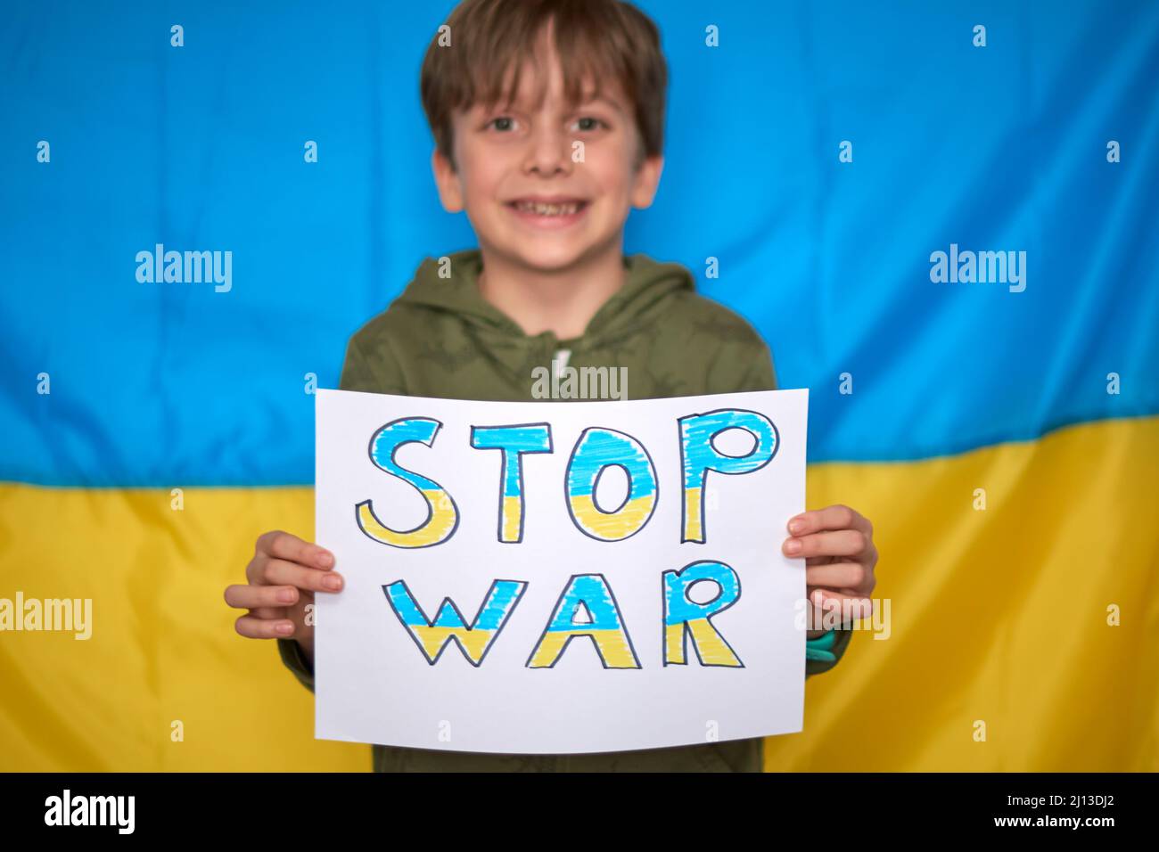 Boy hands holding yellowblue paper drawn banner on Ukrainian flag