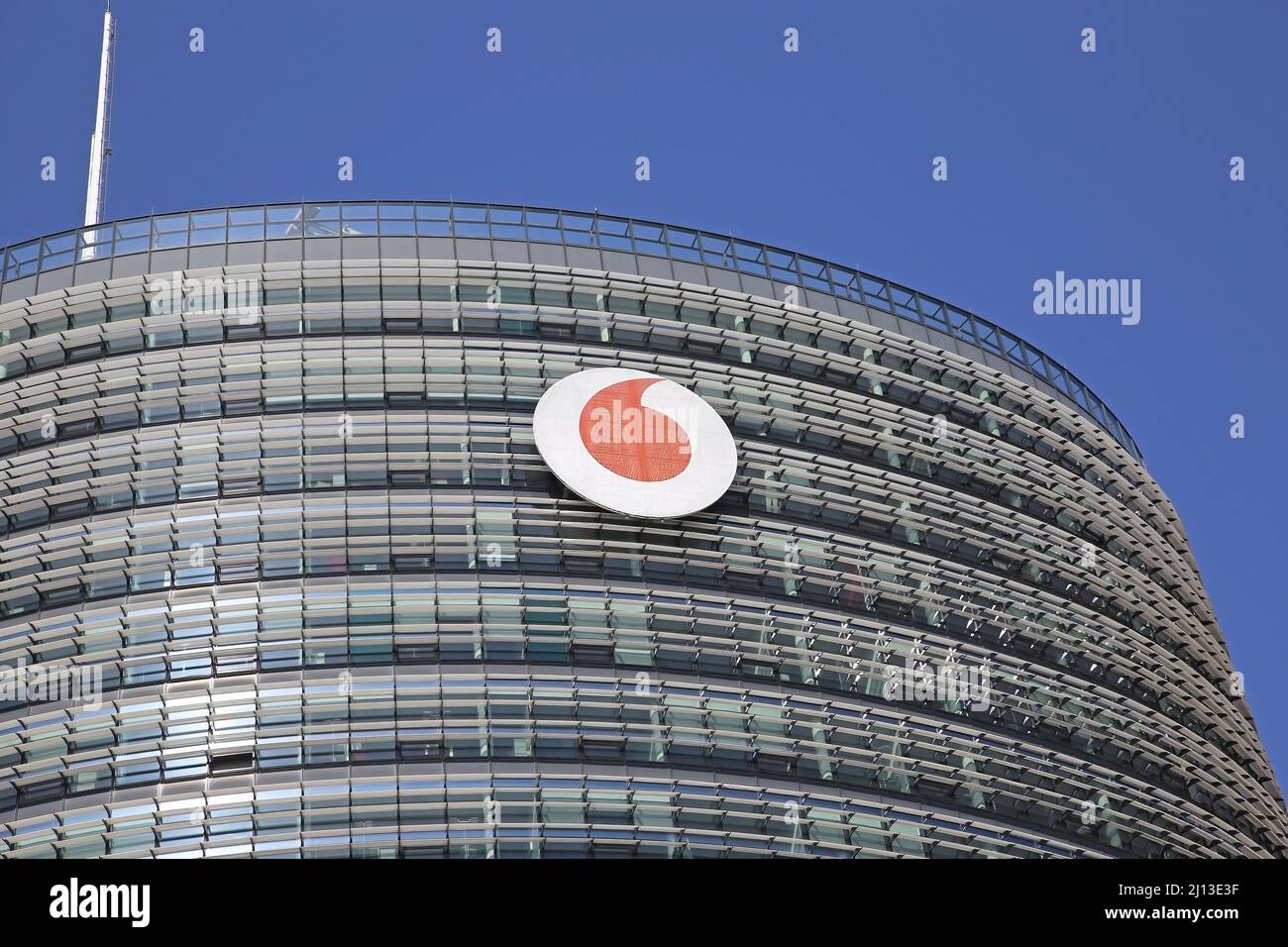 Düsseldorf (Vodafone campus) - March 9. 2022: Closeup of tower top with red logo of telecommunication company against clear blue sky Stock Photo