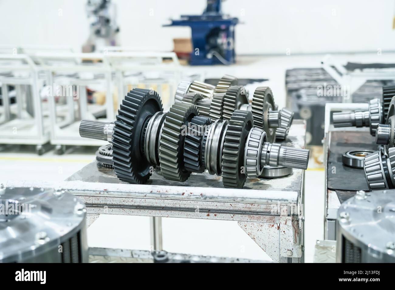 Part of gearshift transmission with gear wheels of industrial machine in combine harvester factory. Stock Photo