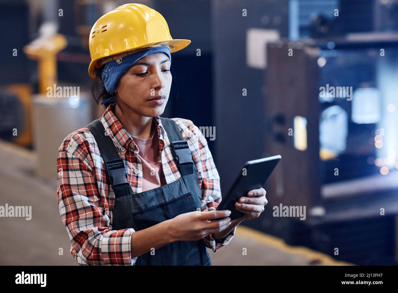 Woman Quality Control Young serious female manager of quality control using digital tablet to ...