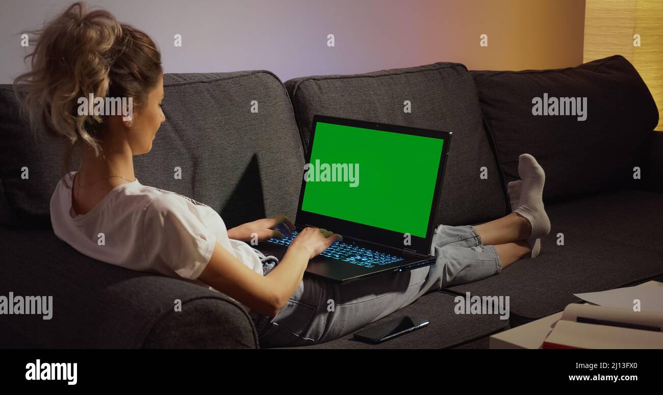 Chroma Key Green Screen Laptop Computer. Woman working typing home evening late. Remote work. Technology concept. Stock Photo