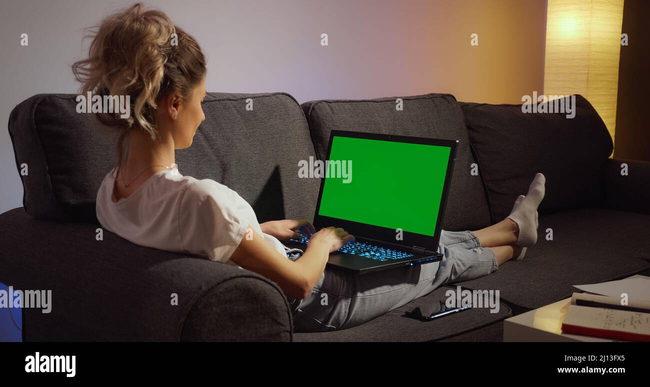 Chroma Key Green Screen Laptop Computer. Woman working typing home evening late. Remote work. Technology concept. Stock Photo