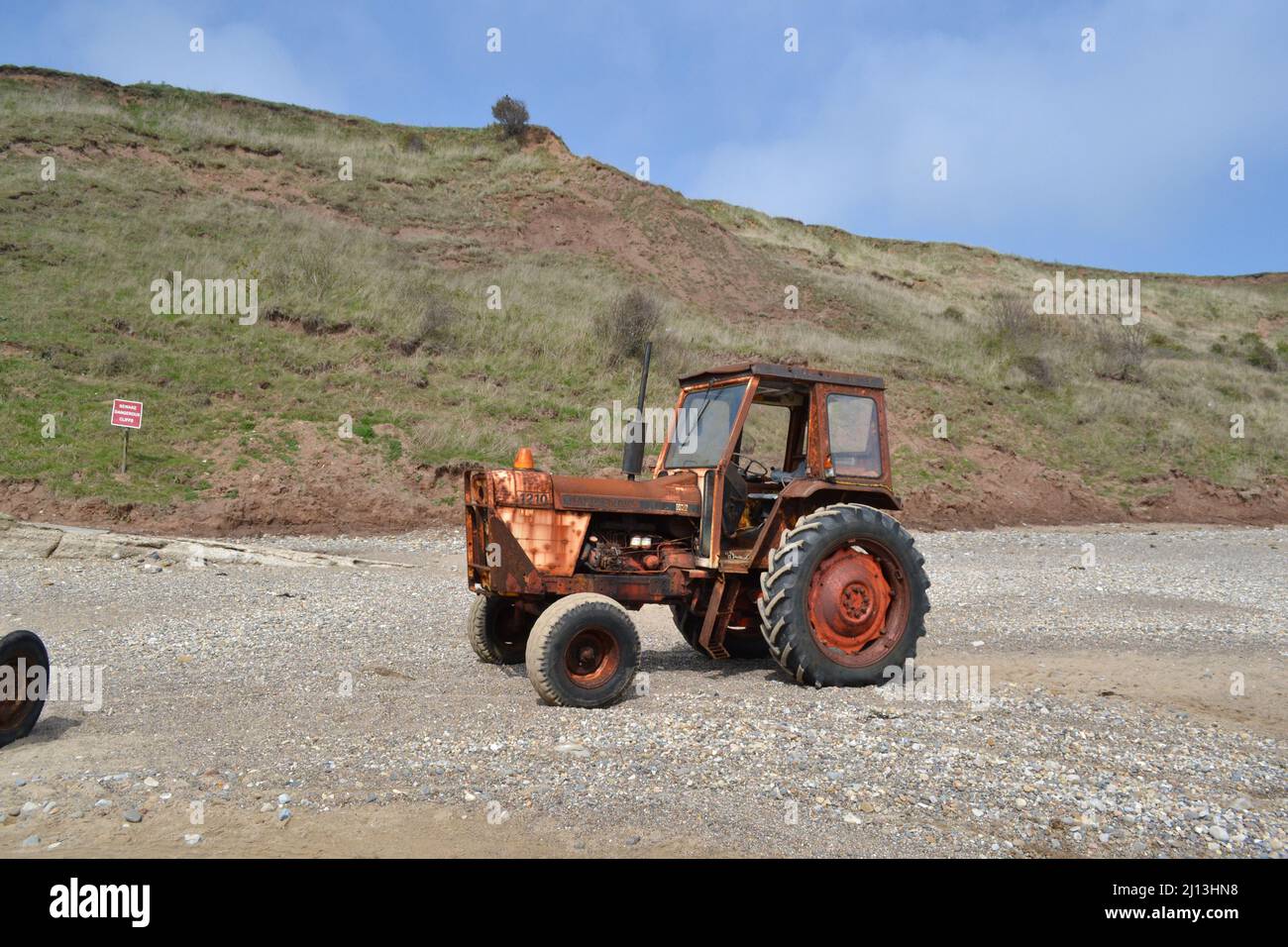 Old Tractor On Filey Beach In The Sunshine - Sand And Stone On Beach - Rusty Tractor - Filey - Yorkshire - UK Stock Photo