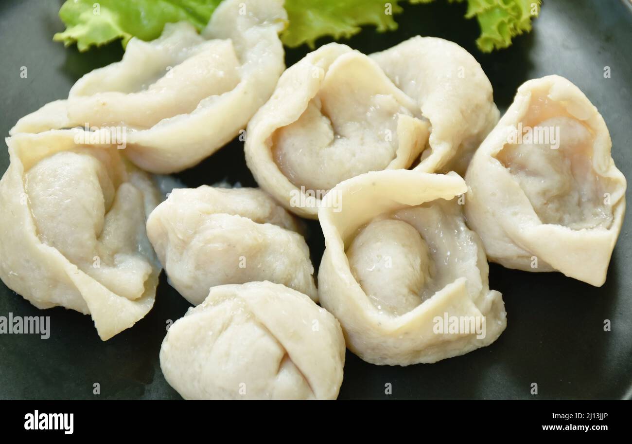 steamed fish dumpling with lettuce on plate dipping spicy and sour