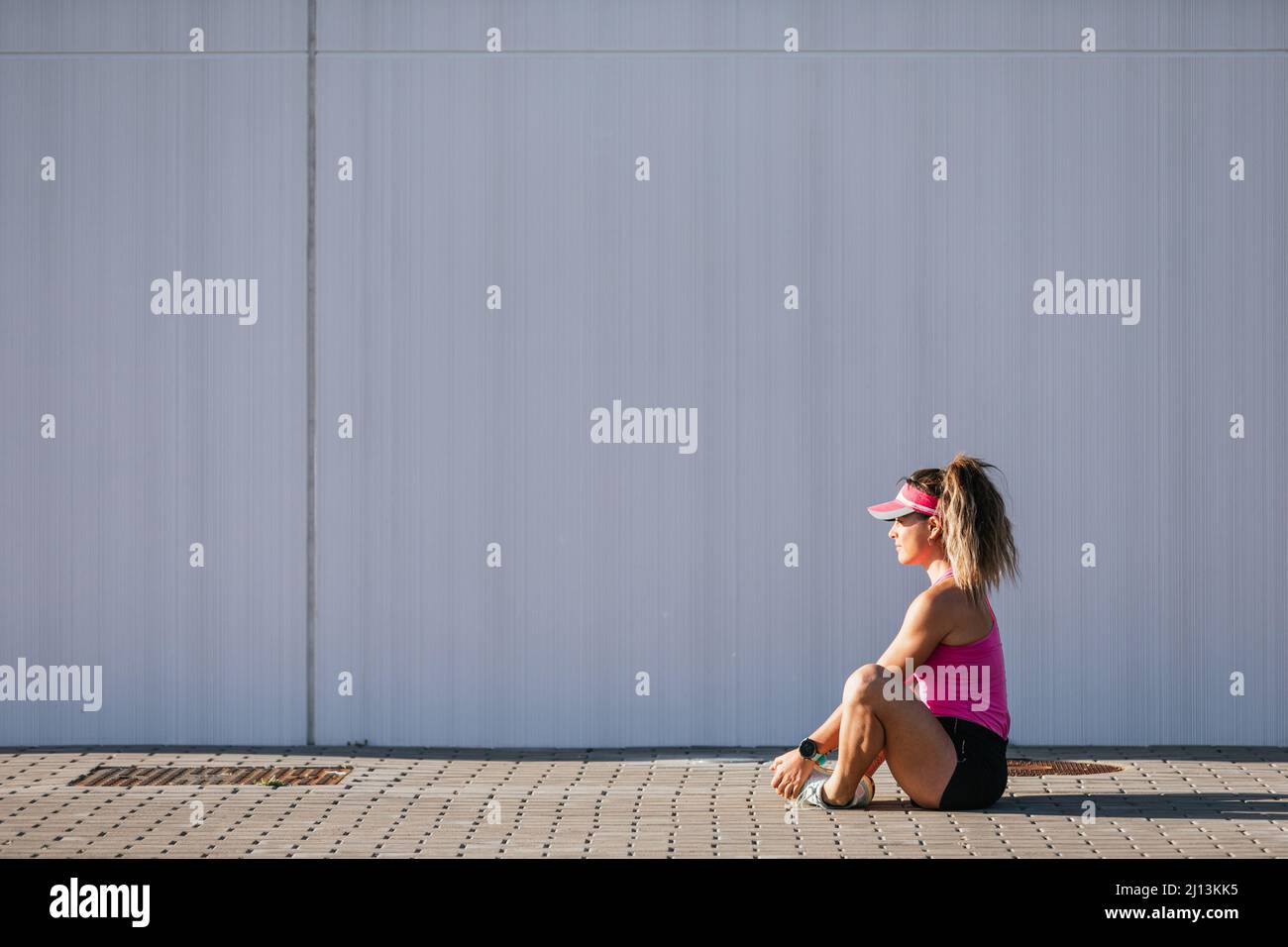 Sporty woman stretching her legs in the street Stock Photo - Alamy