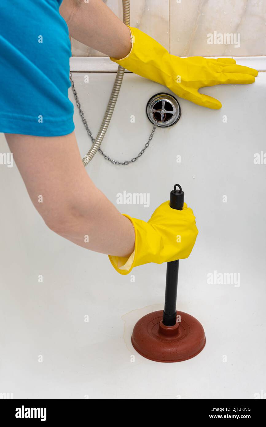 https://c8.alamy.com/comp/2J13KNG/a-man-in-rubber-gloves-cleans-the-drain-in-the-bathroom-with-a-plunger-high-quality-photo-2J13KNG.jpg