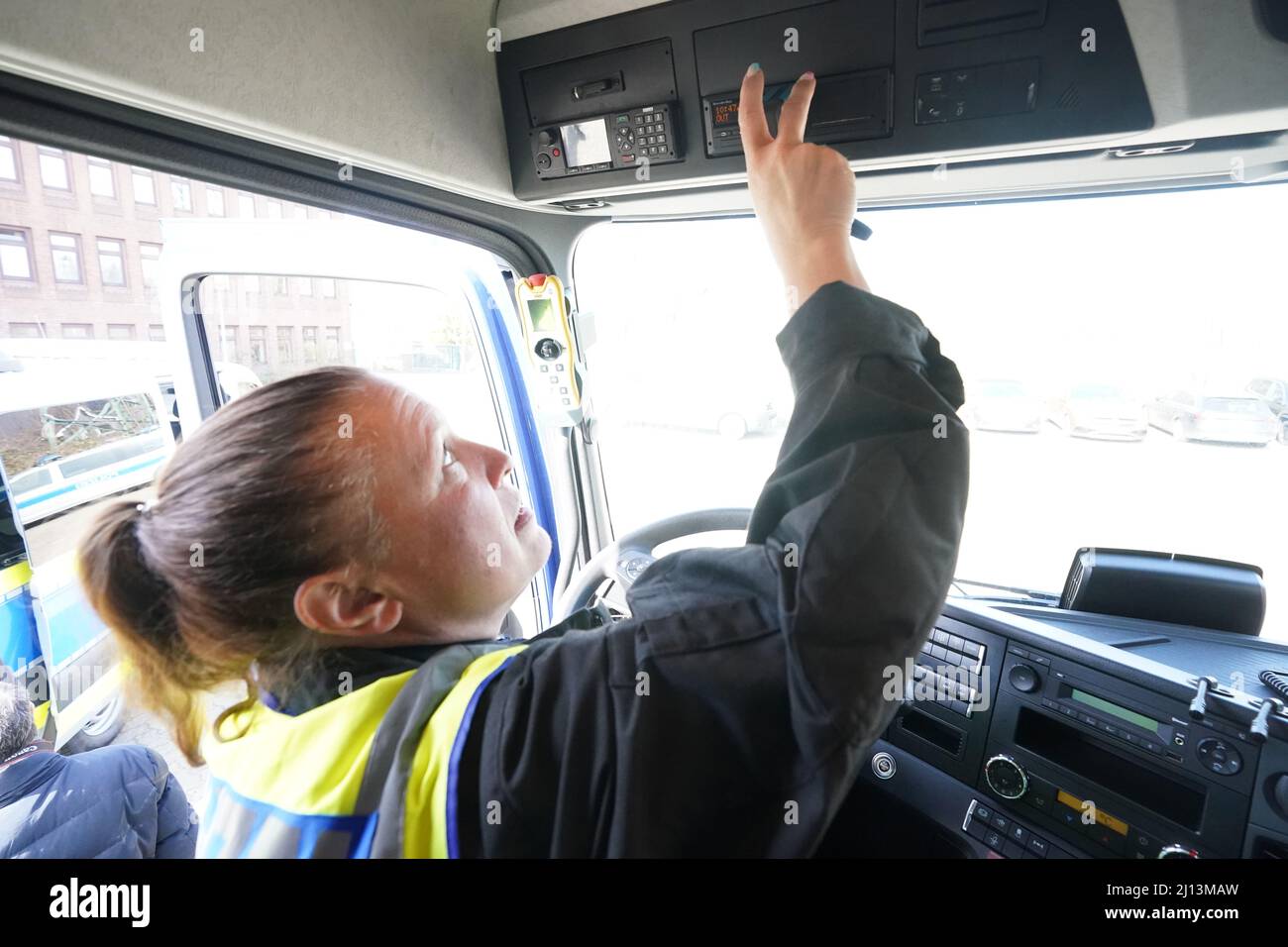 Hamburg, Germany. 22nd Mar, 2022. Maren Ilic, a member of the 'Heavy Duty Control Group' (VD 4), checks the tachograph of a truck during a press event. The police's new special unit has put a new heavy-load control vehicle into service. The task force vehicle is equipped with special devices and materials to check vehicles weighing tons in freight and heavy goods traffic. Credit: Marcus Brandt/dpa/Alamy Live News Stock Photo
