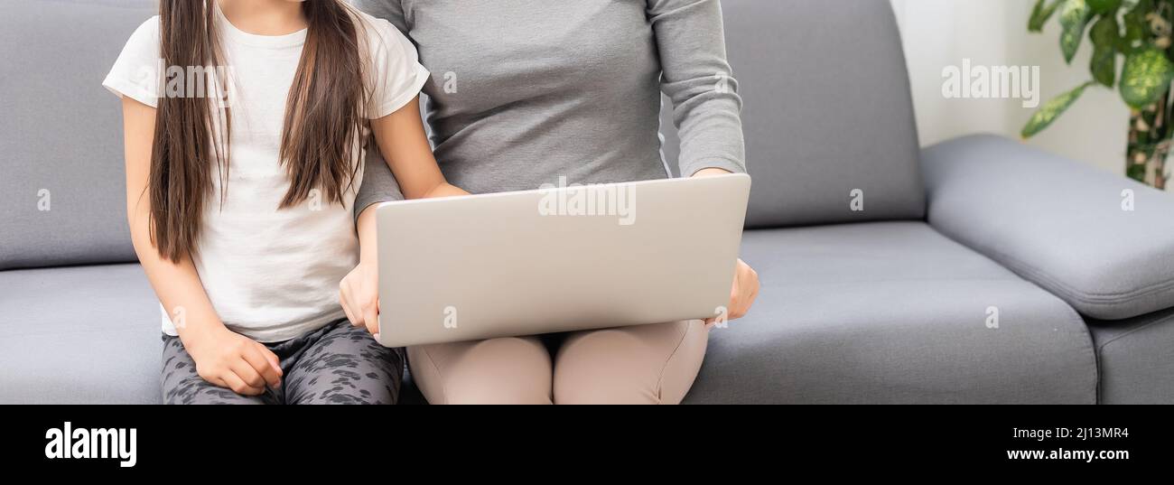 Helpful mother explaining to daughter about using a laptop Stock Photo