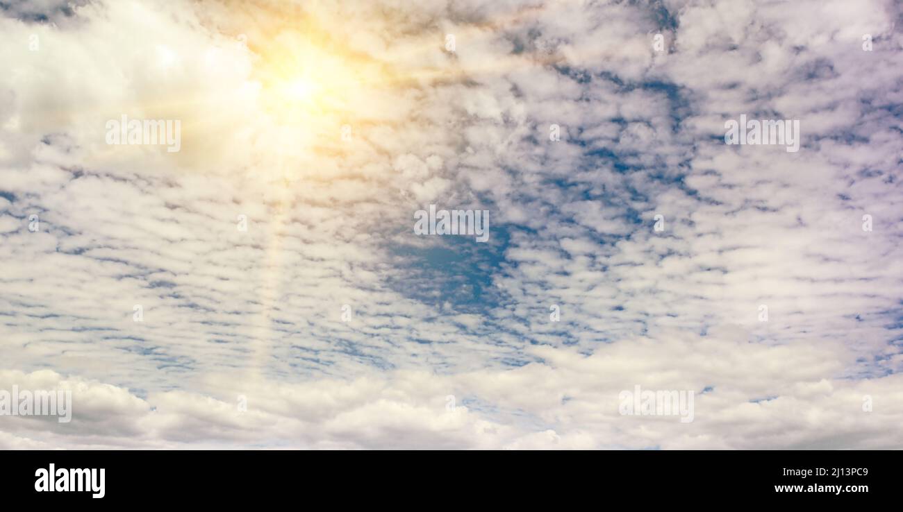 Bright sun on blue sky with white clouds Stock Photo - Alamy