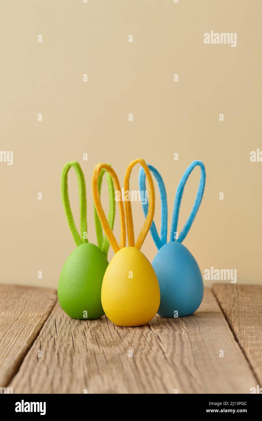 Colorful Easter eggs with bunny ears on beige background Stock Photo