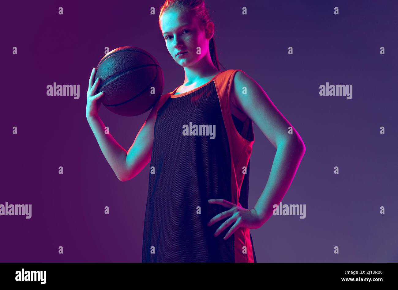 Portrait of girl, teenager, basketball player in uniform posing with