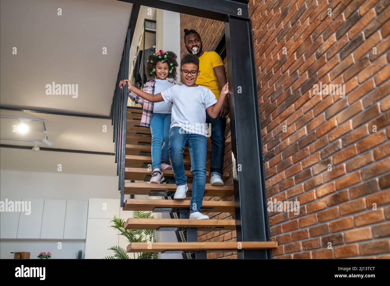 Boy girl and man going down stairs at home Stock Photo