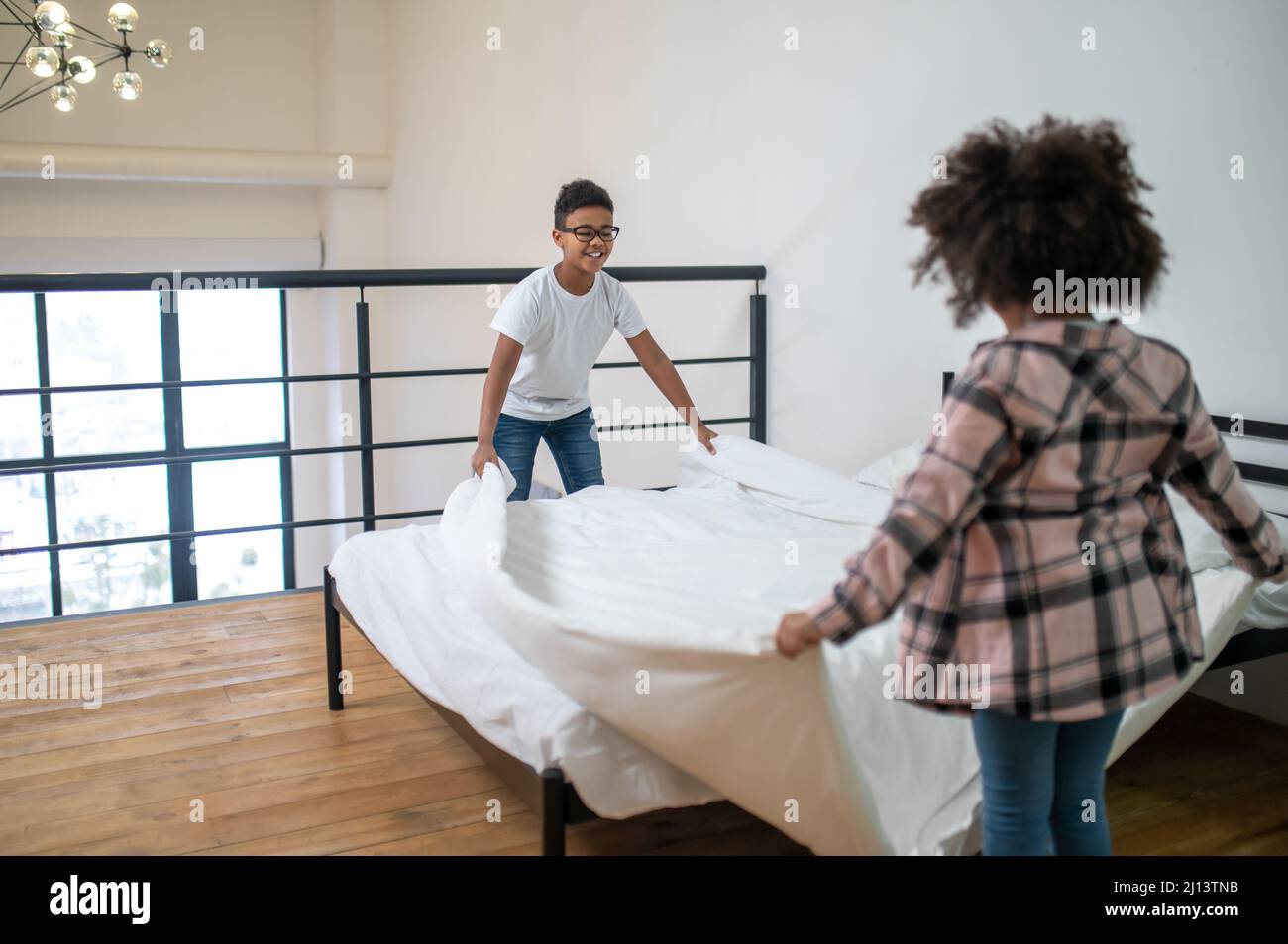 Boy and girl laying sheets on bed Stock Photo Alamy