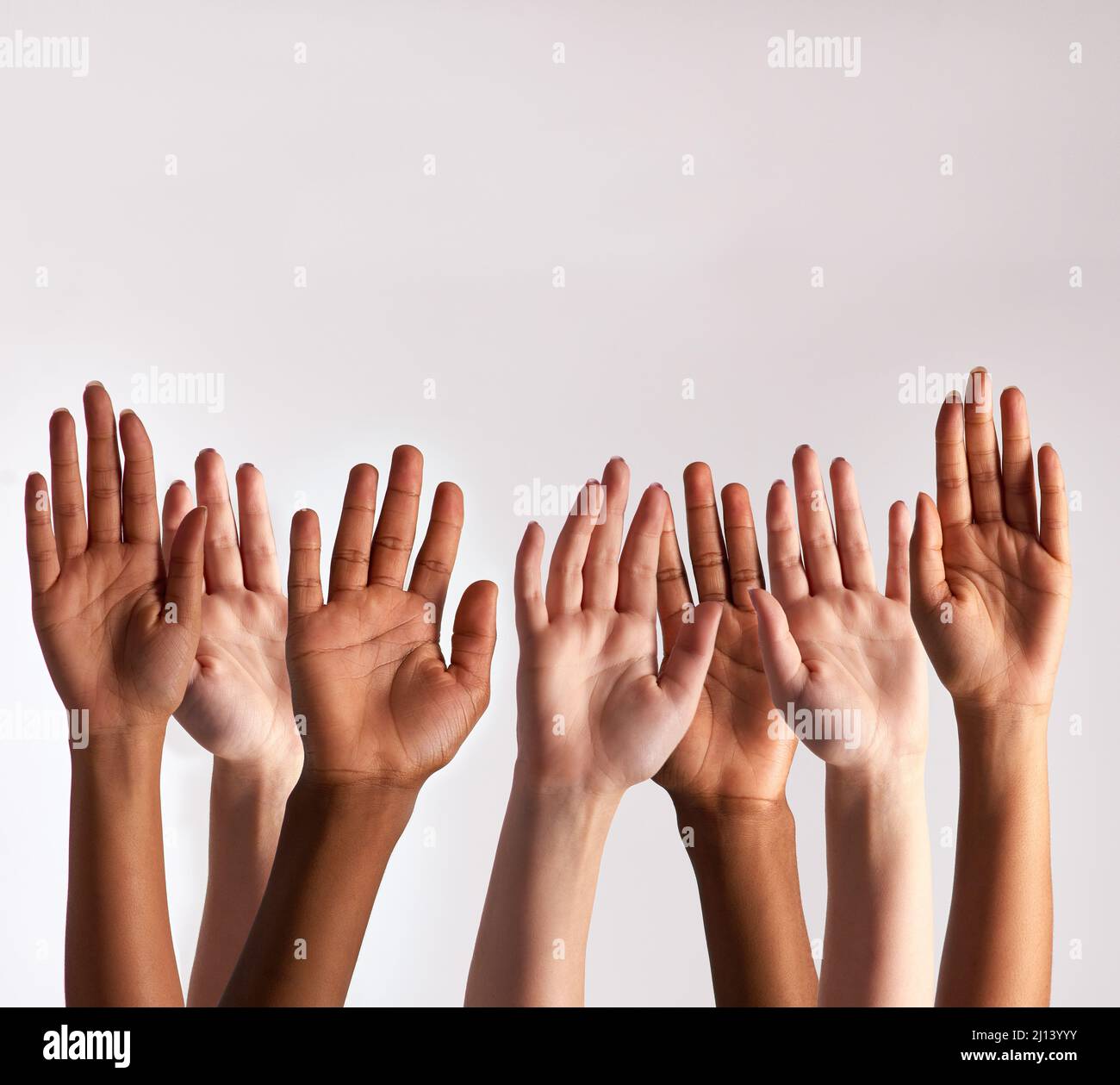 Raise your hands if you support diversity. Cropped shot of a diverse group of people raising their hands. Stock Photo