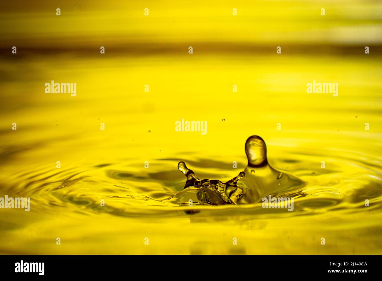 Drop splashing in yellow water Stock Photo Alamy