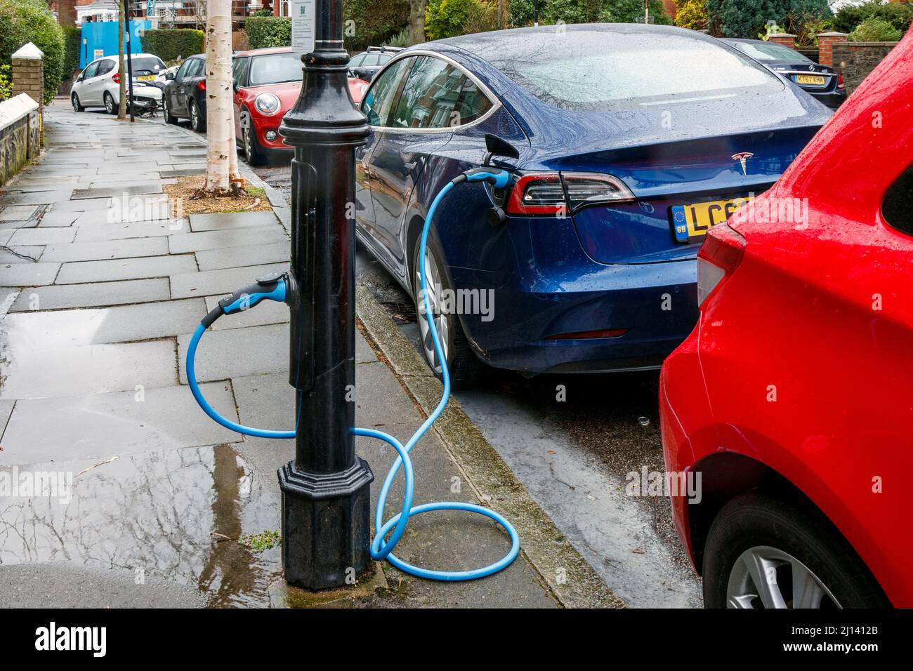 An electric vehicle recharging from a point in a lamp post in a