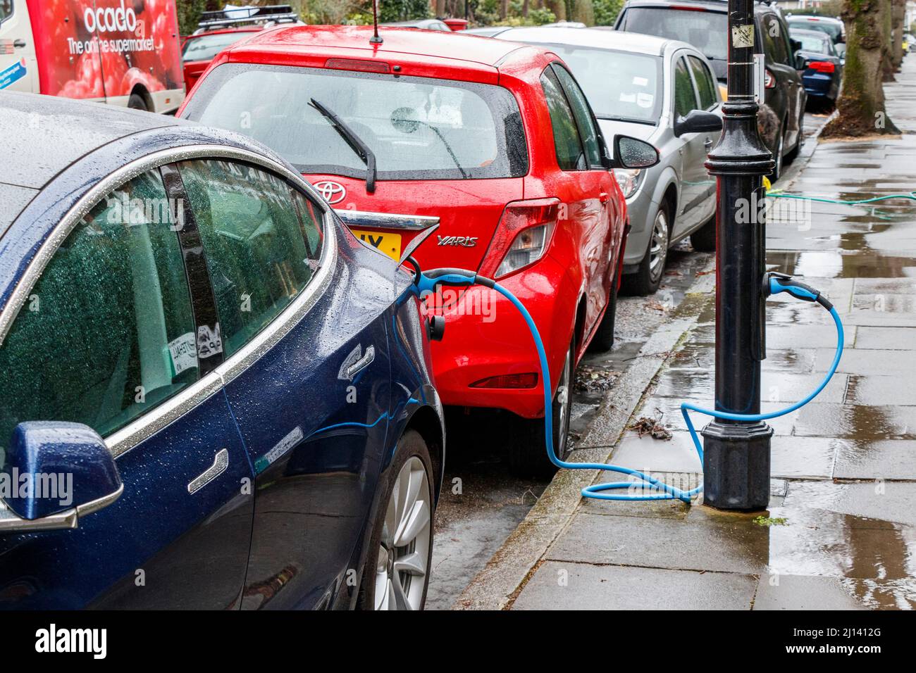 An electric vehicle recharging from a point in a lamp post in a