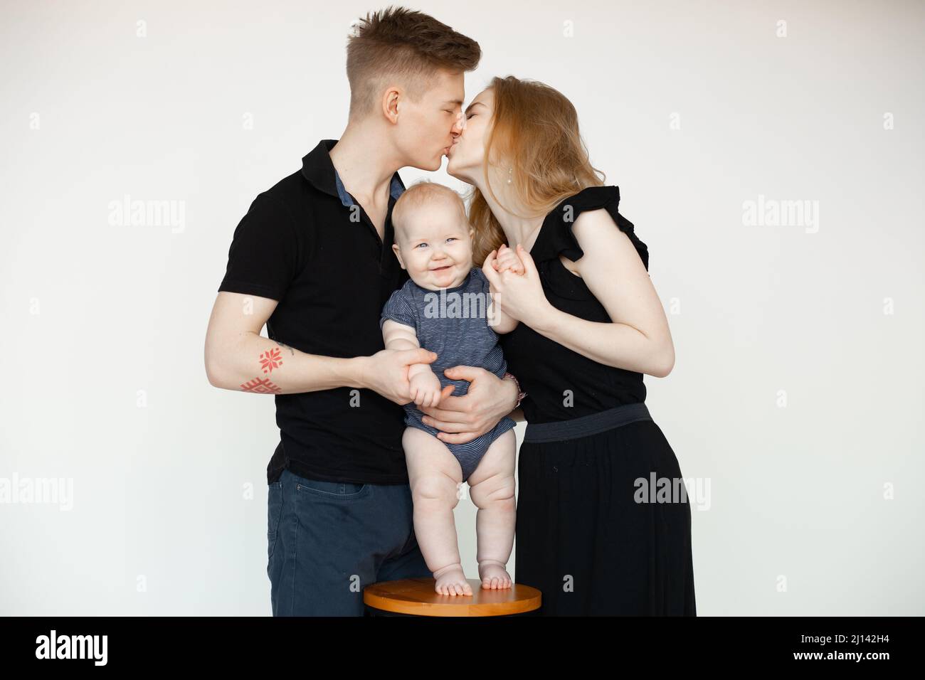 Portrait of smiling calm family, woman, man, baby, hugging, spending time together. Celebration of anniversary marriage Stock Photo