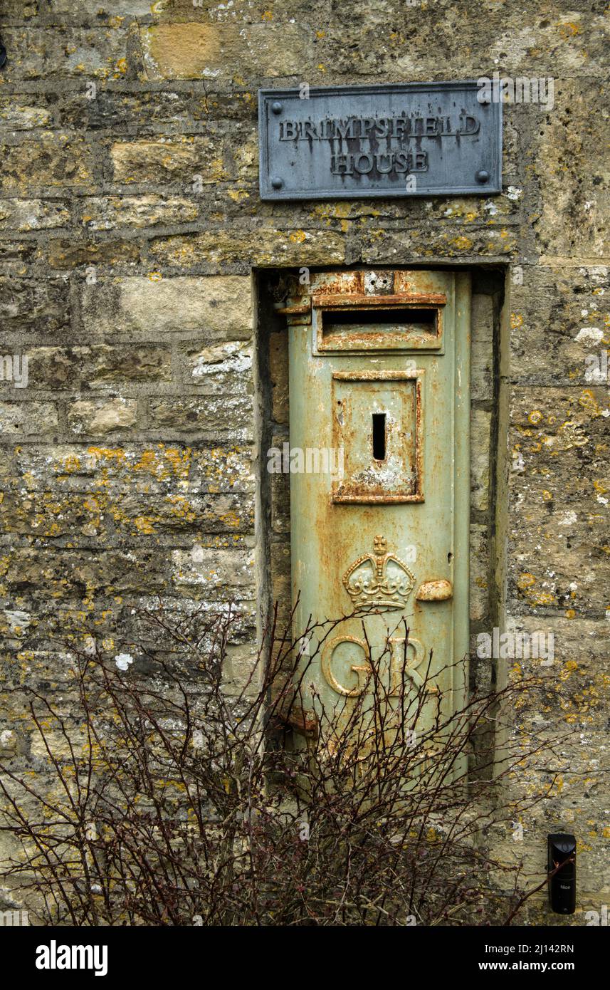 A pale green GR or George Rex letterbox embedded in a house wall in the Cotswolds village of Brimpsfield in Gloucestershire Stock Photo
