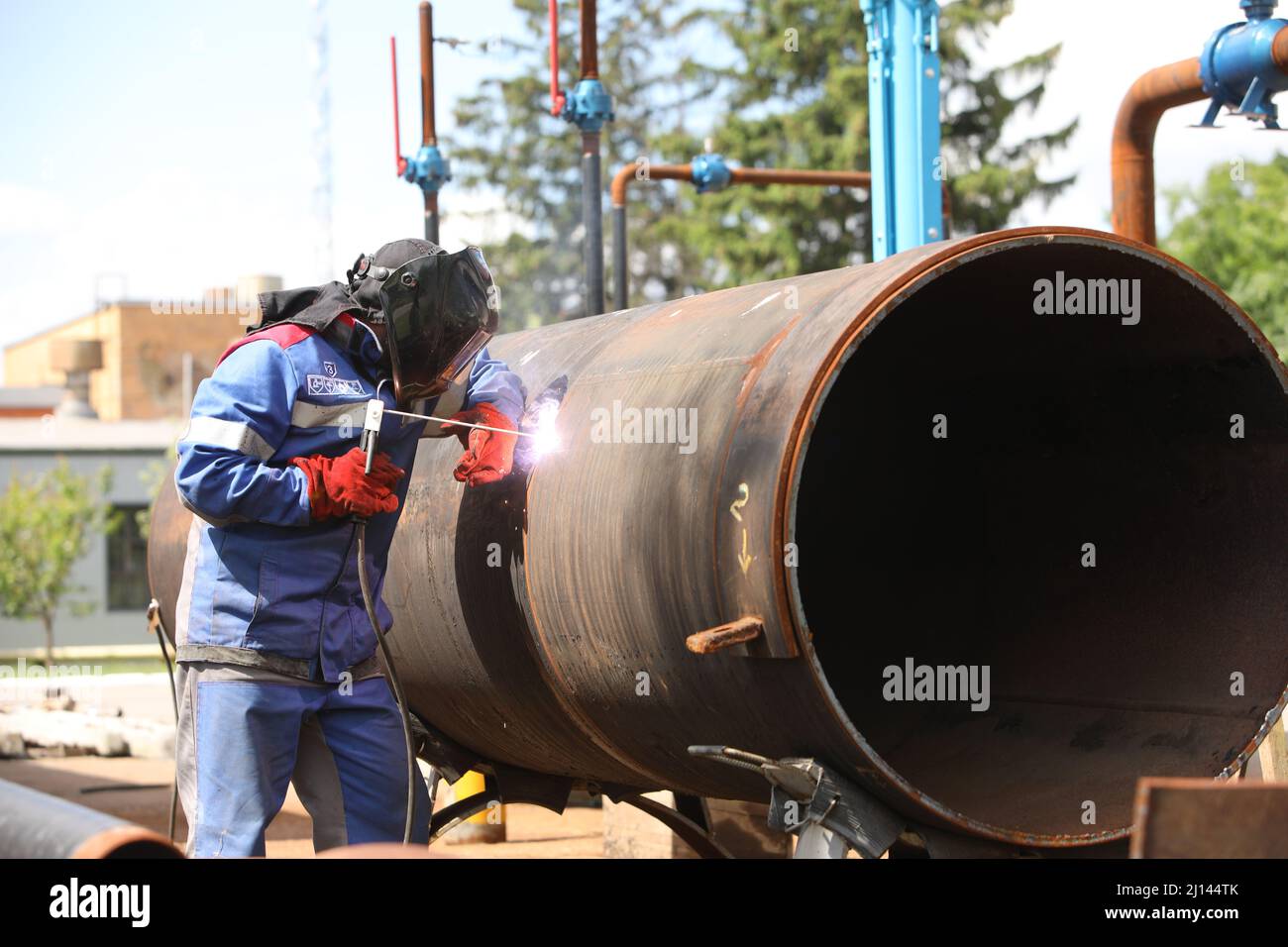 Male welder works. Welding joint of large diameter pipe. High pressure