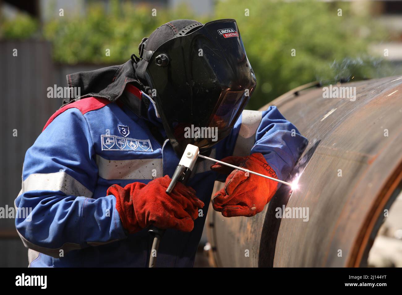 Male welder works. Welding joint of large diameter pipe. High pressure