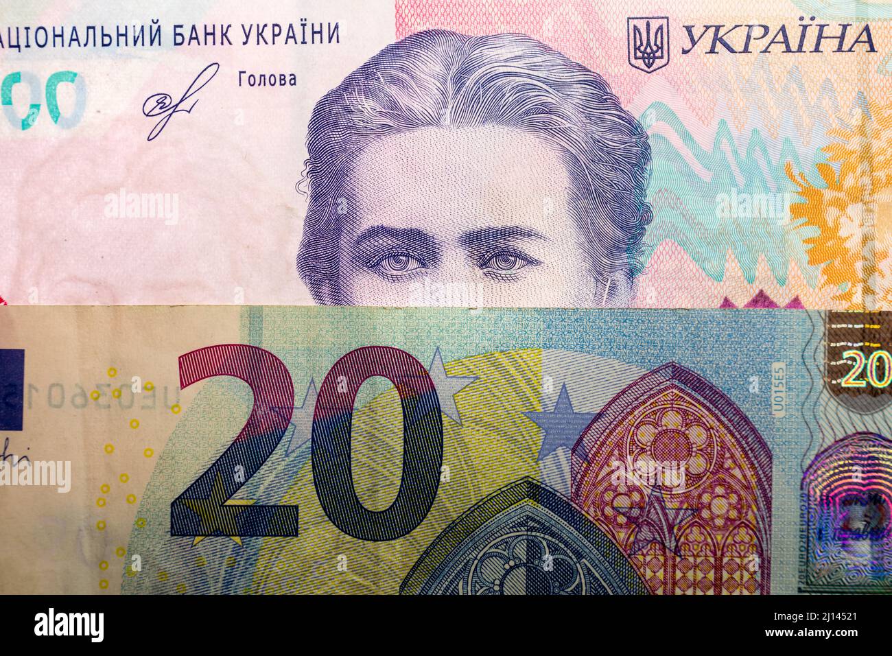 In this photo illustration, 20 euro note and Ukrainian 200 hryvnias banknote with the image of Lesya Ukrainka are seen displayed. Stock Photo