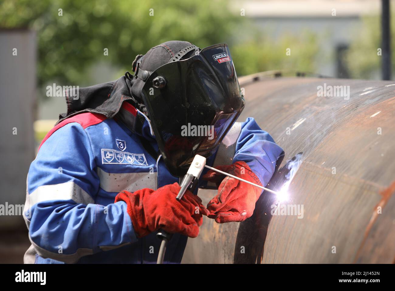 Male welder works. Welding joint of large diameter pipe. High pressure