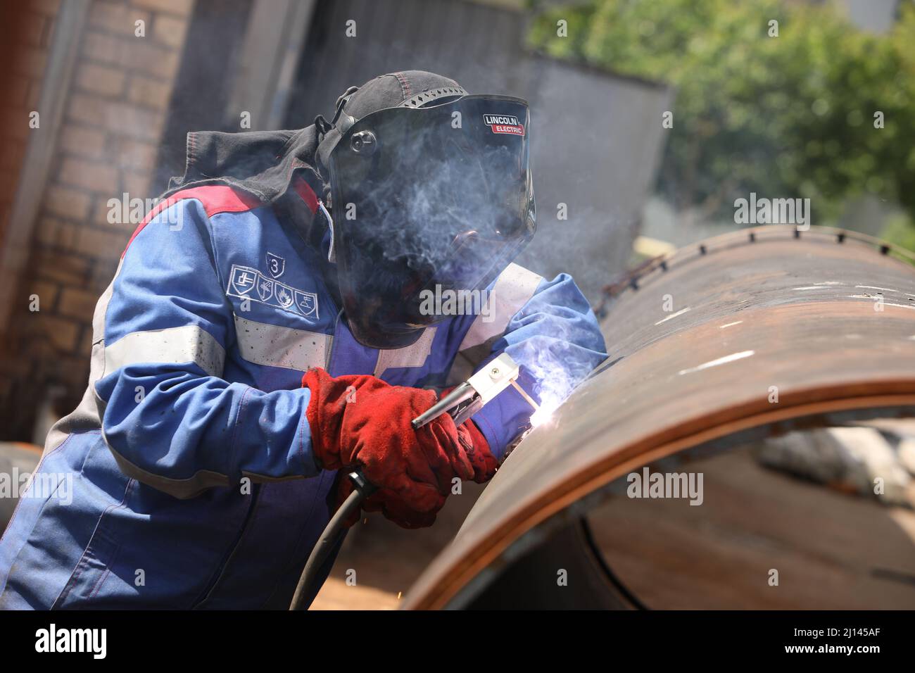 Male welder works. Welding joint of large diameter pipe. High pressure
