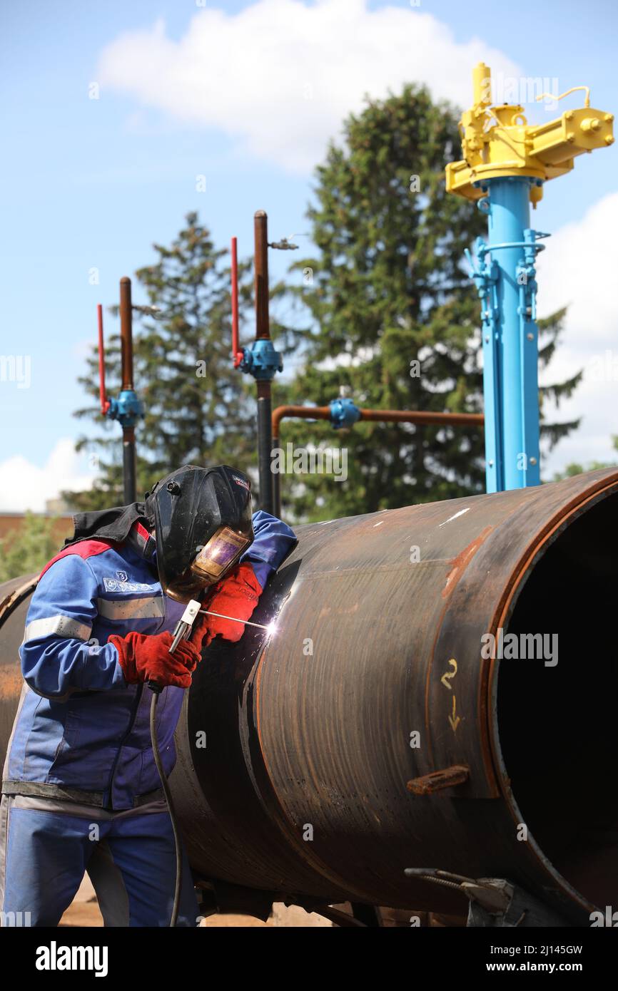 Male welder works. Welding joint of large diameter pipe. High pressure